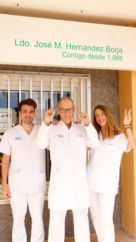 Un grupo de personas de pie frente a un cartel que dice Luc José M. Hernández Bona.